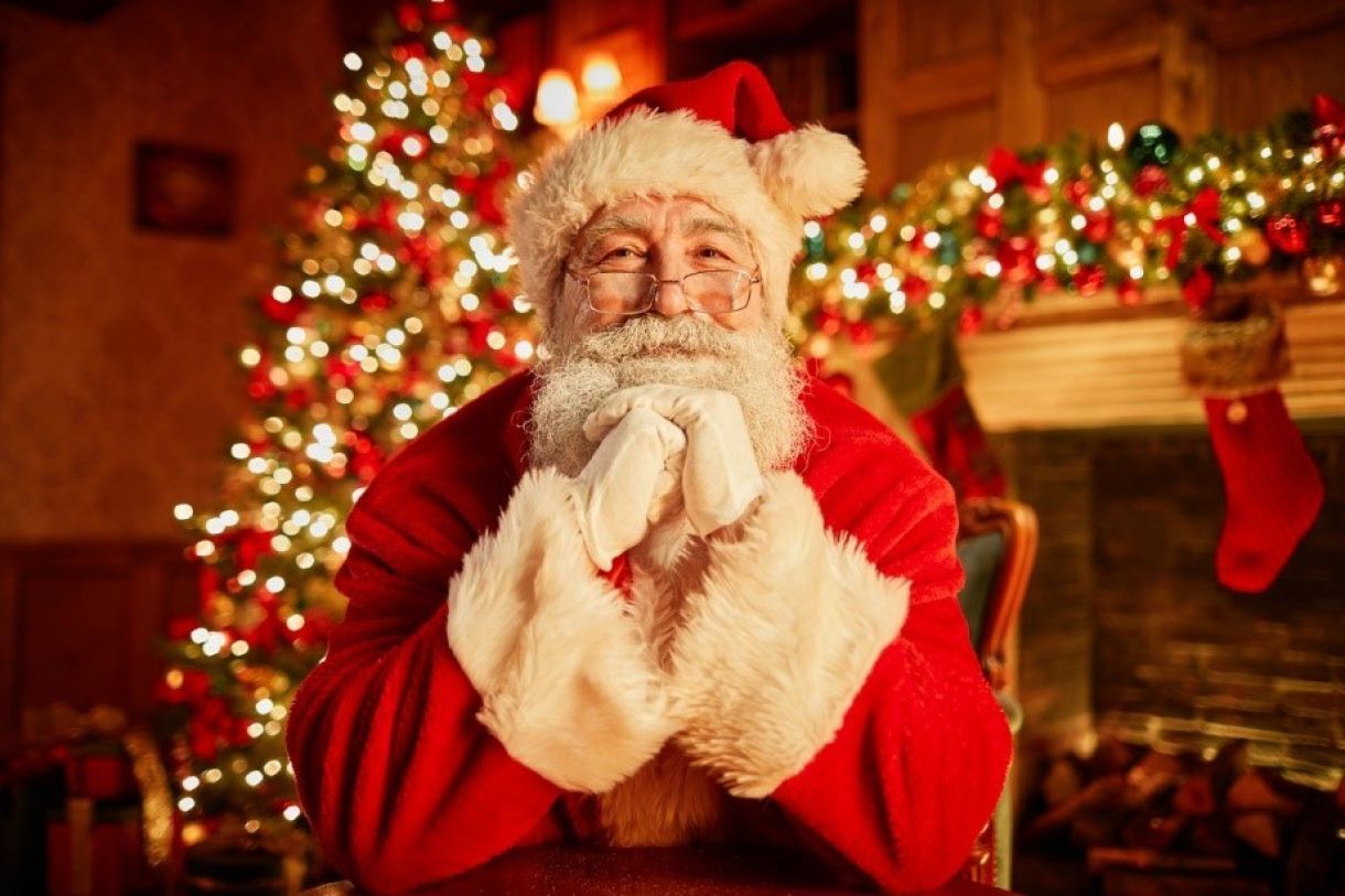 Father christmas smiling in front of a decorating lounge